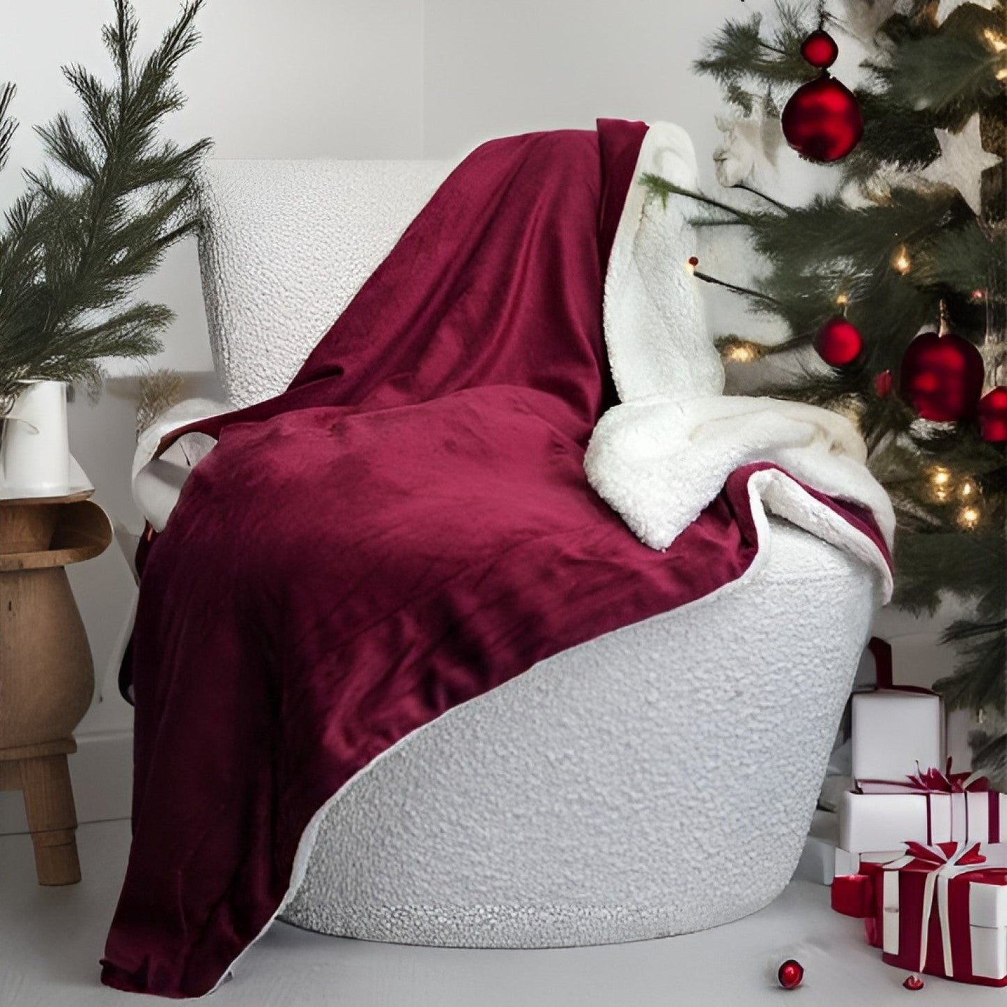 White chair with a red blanket draped over it, Christmas tree with decorations in the background