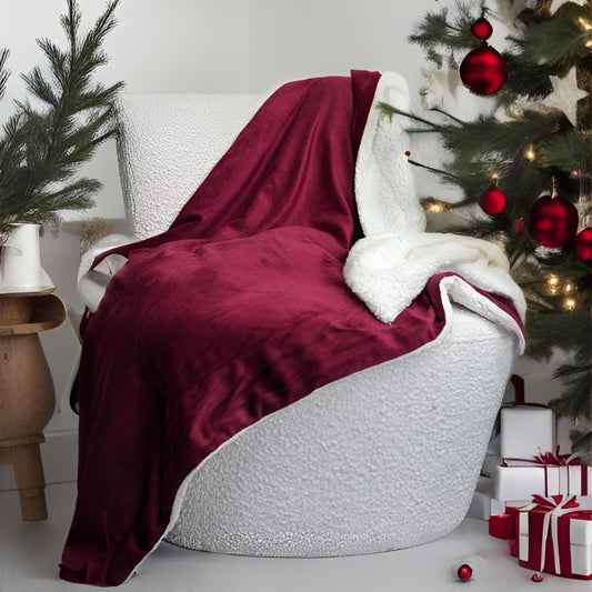 White chair with a red blanket draped over it, Christmas tree with decorations in the background